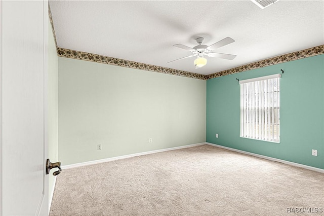 empty room with visible vents, baseboards, ceiling fan, carpet, and a textured ceiling