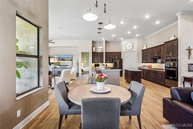 dining space featuring ornamental molding, light wood finished floors, recessed lighting, and baseboards