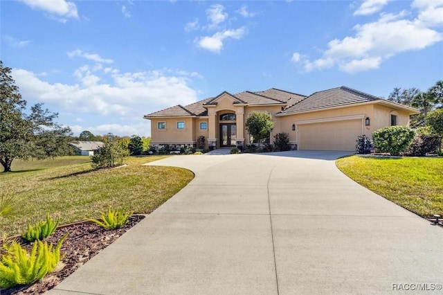 mediterranean / spanish home featuring concrete driveway, french doors, a front yard, and stucco siding