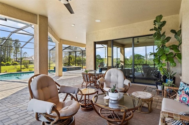 sunroom featuring ceiling fan and a pool