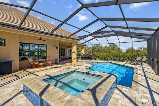 view of pool featuring glass enclosure, a patio, and ceiling fan