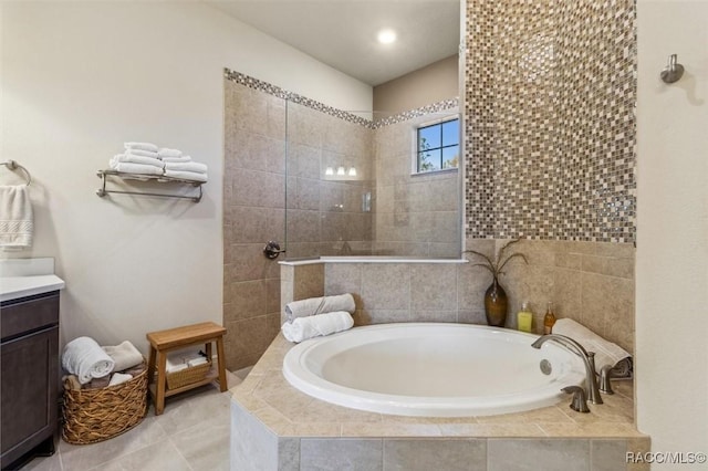 full bathroom featuring tile patterned flooring, a garden tub, vanity, and a walk in shower