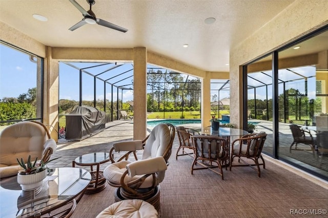 sunroom with ceiling fan and a pool