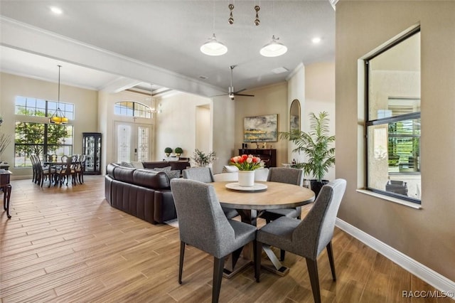 dining area featuring light wood-style flooring, baseboards, and crown molding