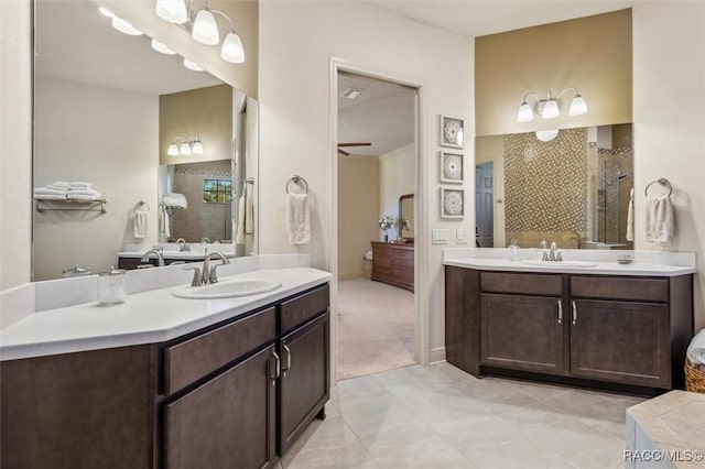 full bathroom featuring tiled shower, two vanities, a sink, and a ceiling fan