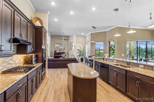 kitchen with under cabinet range hood, a sink, open floor plan, black dishwasher, and stainless steel gas stovetop