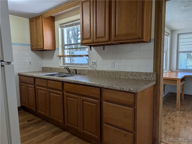 kitchen featuring tasteful backsplash, sink, a textured ceiling, and white refrigerator