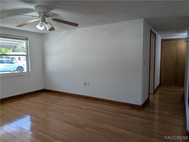 unfurnished room with a textured ceiling, ceiling fan, and dark hardwood / wood-style floors