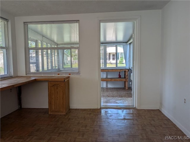 doorway with dark parquet flooring and plenty of natural light