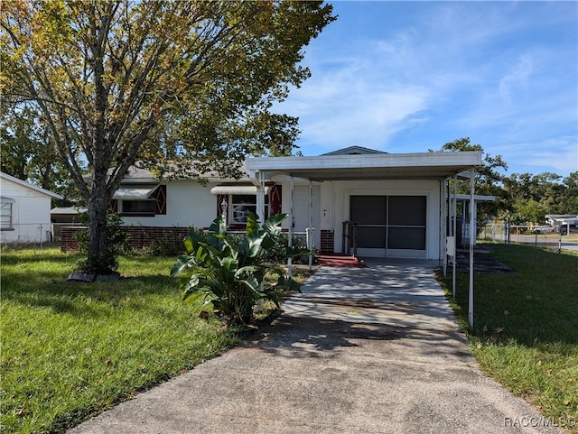 ranch-style home featuring a carport and a front lawn