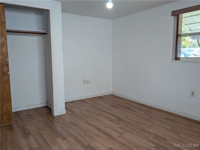 unfurnished bedroom featuring hardwood / wood-style flooring and a closet