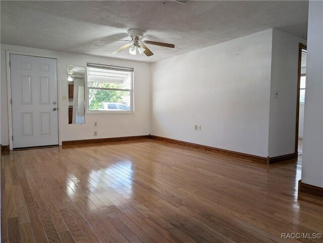 interior space with a textured ceiling, light hardwood / wood-style floors, and ceiling fan