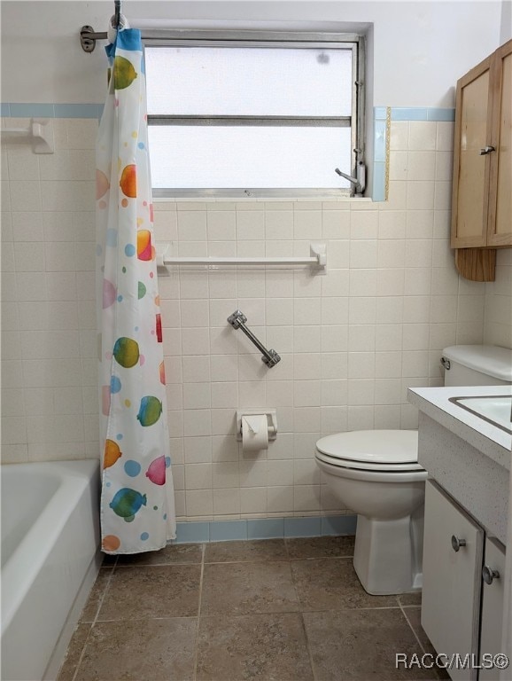 full bathroom featuring vanity, plenty of natural light, shower / bathtub combination with curtain, and tile walls