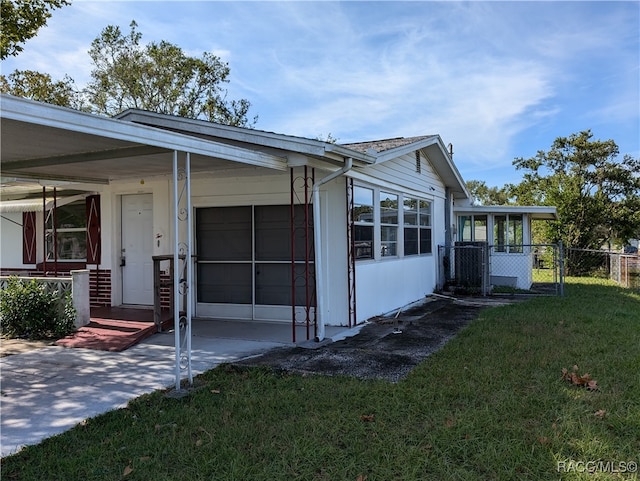 view of side of home featuring a lawn and a carport