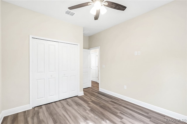 unfurnished bedroom with a closet, light hardwood / wood-style floors, and ceiling fan