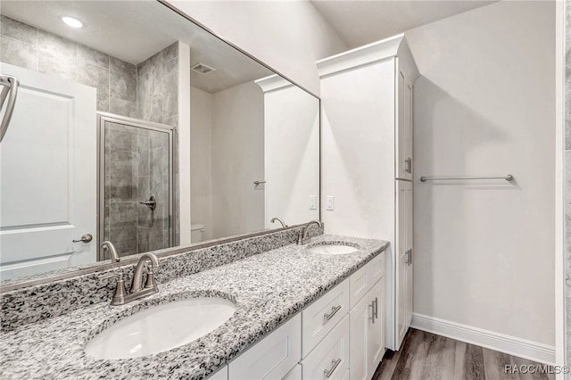 bathroom featuring toilet, vanity, wood-type flooring, and walk in shower