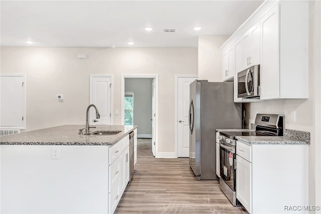 kitchen featuring white cabinetry, sink, stainless steel appliances, and light stone counters