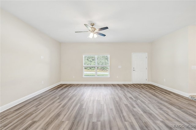 empty room with ceiling fan and light hardwood / wood-style floors