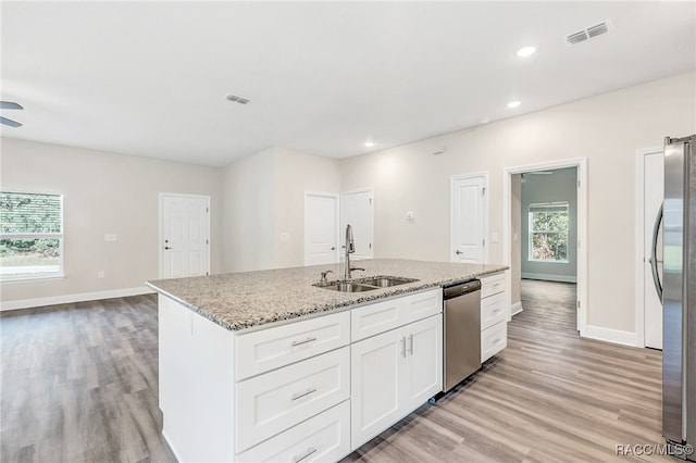 kitchen with white cabinetry, sink, appliances with stainless steel finishes, and light hardwood / wood-style flooring