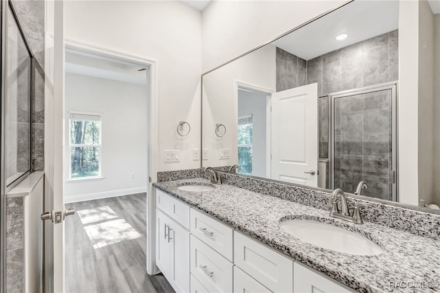 bathroom with hardwood / wood-style floors, vanity, and an enclosed shower