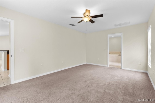 spare room featuring light carpet and ceiling fan