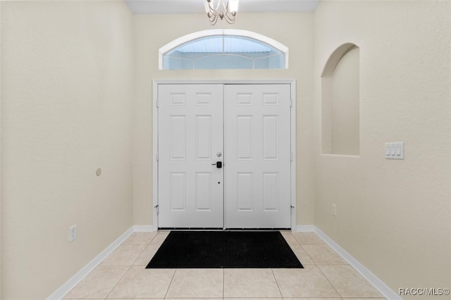 tiled entryway featuring an inviting chandelier