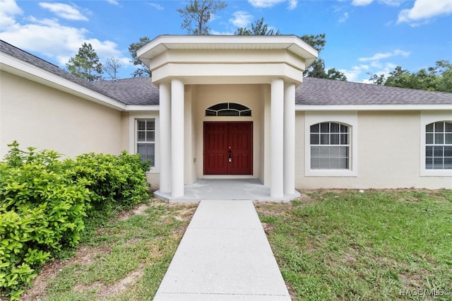 doorway to property with a lawn