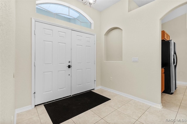 entrance foyer with light tile patterned flooring and a notable chandelier