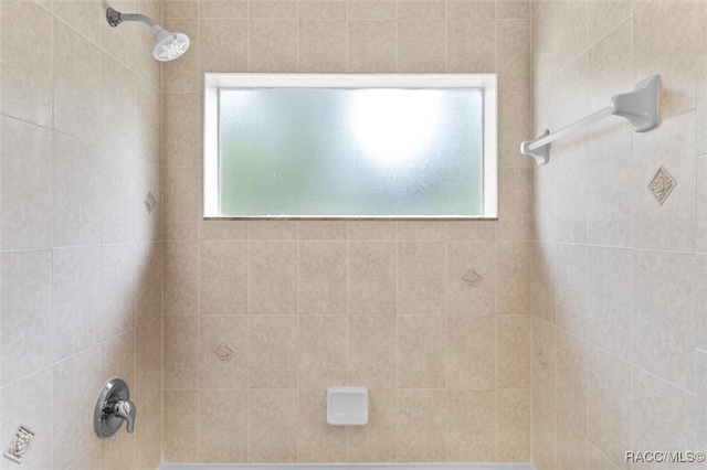 bathroom featuring tiled shower / bath and a wealth of natural light