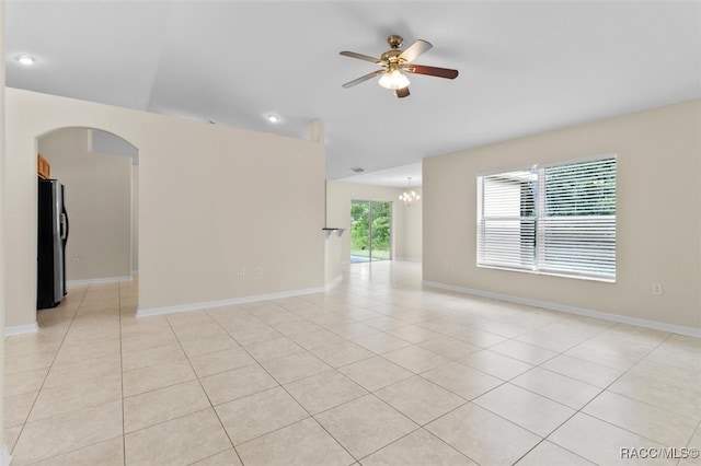 unfurnished room featuring ceiling fan with notable chandelier and light tile patterned flooring