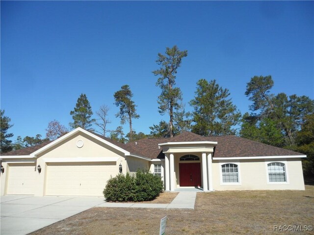 ranch-style home featuring a garage and a front lawn