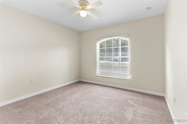 carpeted spare room featuring ceiling fan