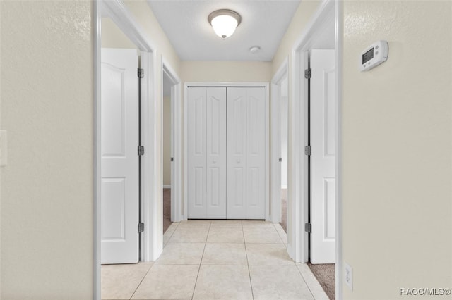 hall with light tile patterned floors