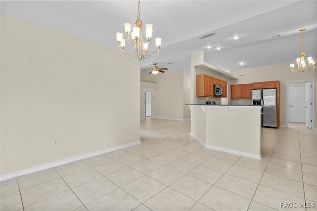 kitchen with lofted ceiling, decorative light fixtures, stainless steel appliances, and an island with sink