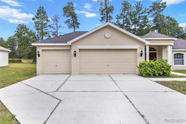 single story home with a garage and a front lawn