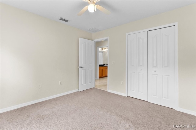 unfurnished bedroom featuring light carpet, a closet, and ceiling fan