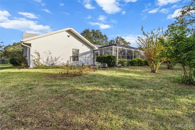 view of property exterior with a lawn and a lanai