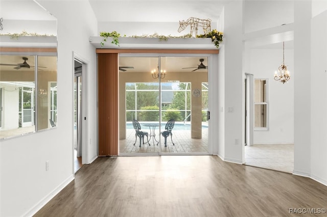 interior space with hardwood / wood-style floors and ceiling fan with notable chandelier