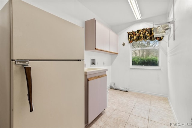 kitchen with white cabinetry, light tile patterned floors, and white refrigerator