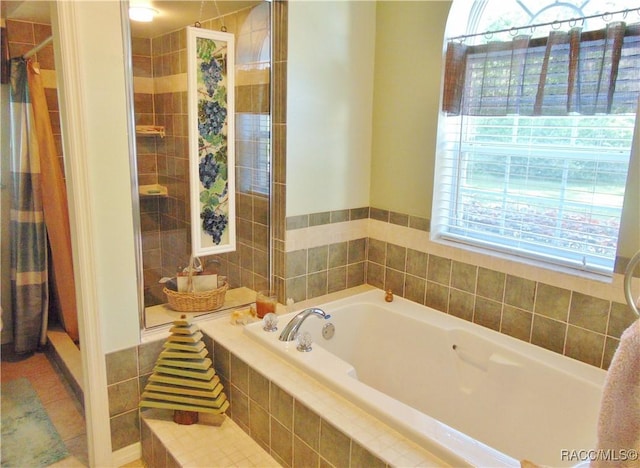 bathroom with independent shower and bath and tile patterned flooring