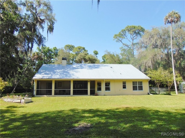 back of property featuring a yard and a sunroom