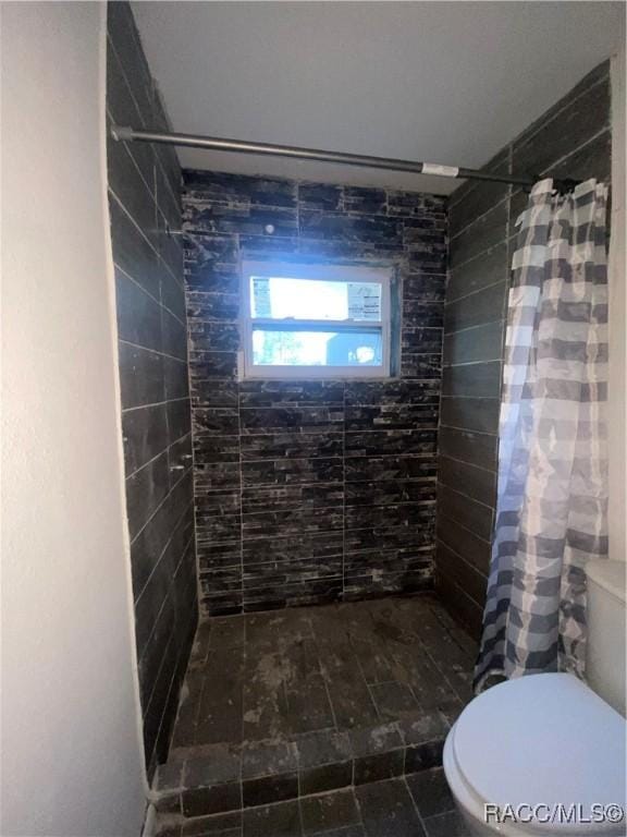 bathroom featuring toilet and a shower with shower curtain