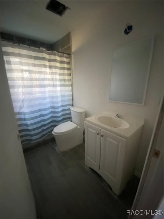 bathroom with vanity, toilet, and walk in shower