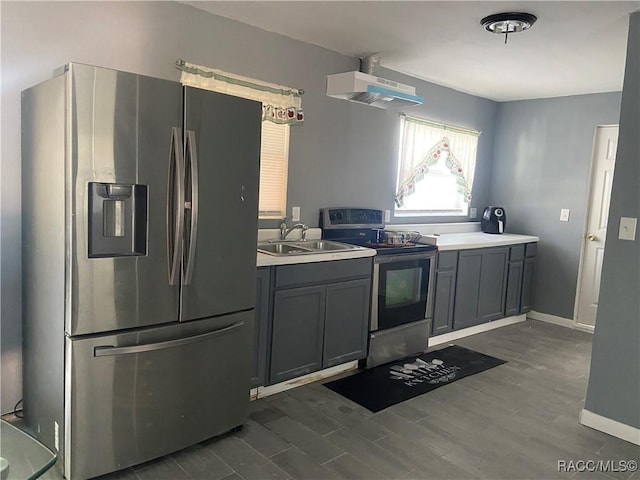 kitchen featuring stainless steel appliances, sink, gray cabinets, dark hardwood / wood-style floors, and range hood