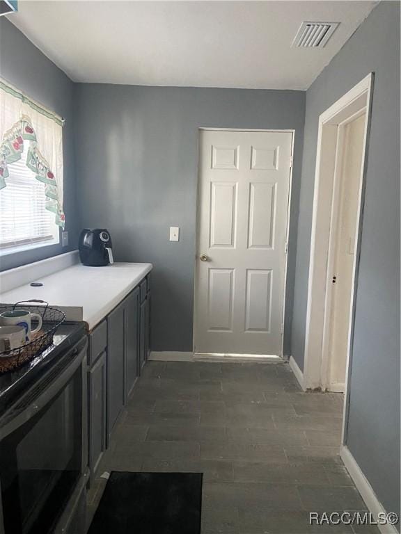 kitchen featuring gray cabinetry, dark hardwood / wood-style floors, and black electric range oven