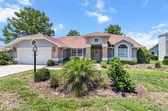6150 N Whispering Oak Loop, Beverly Hills, FL 34465 - view of front facade featuring brick siding, an attached garage, concrete driveway, and stucco siding