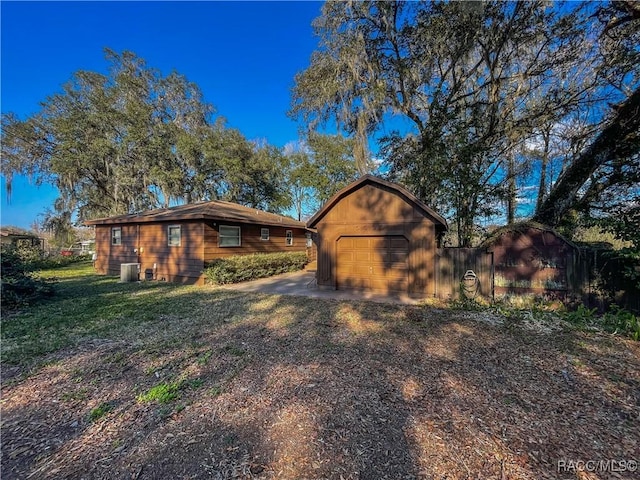 ranch-style home with a garage, central AC, and a front lawn