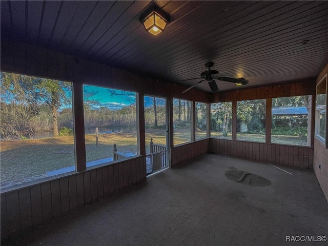 unfurnished sunroom with ceiling fan