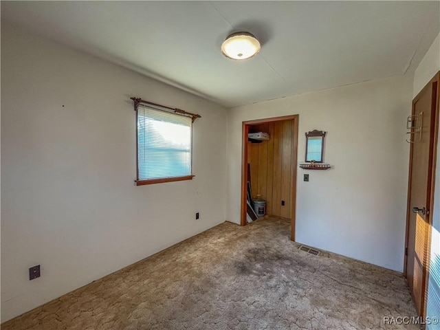 carpeted spare room with a wall unit AC