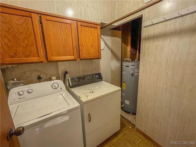 washroom with water heater, washer and dryer, and cabinets